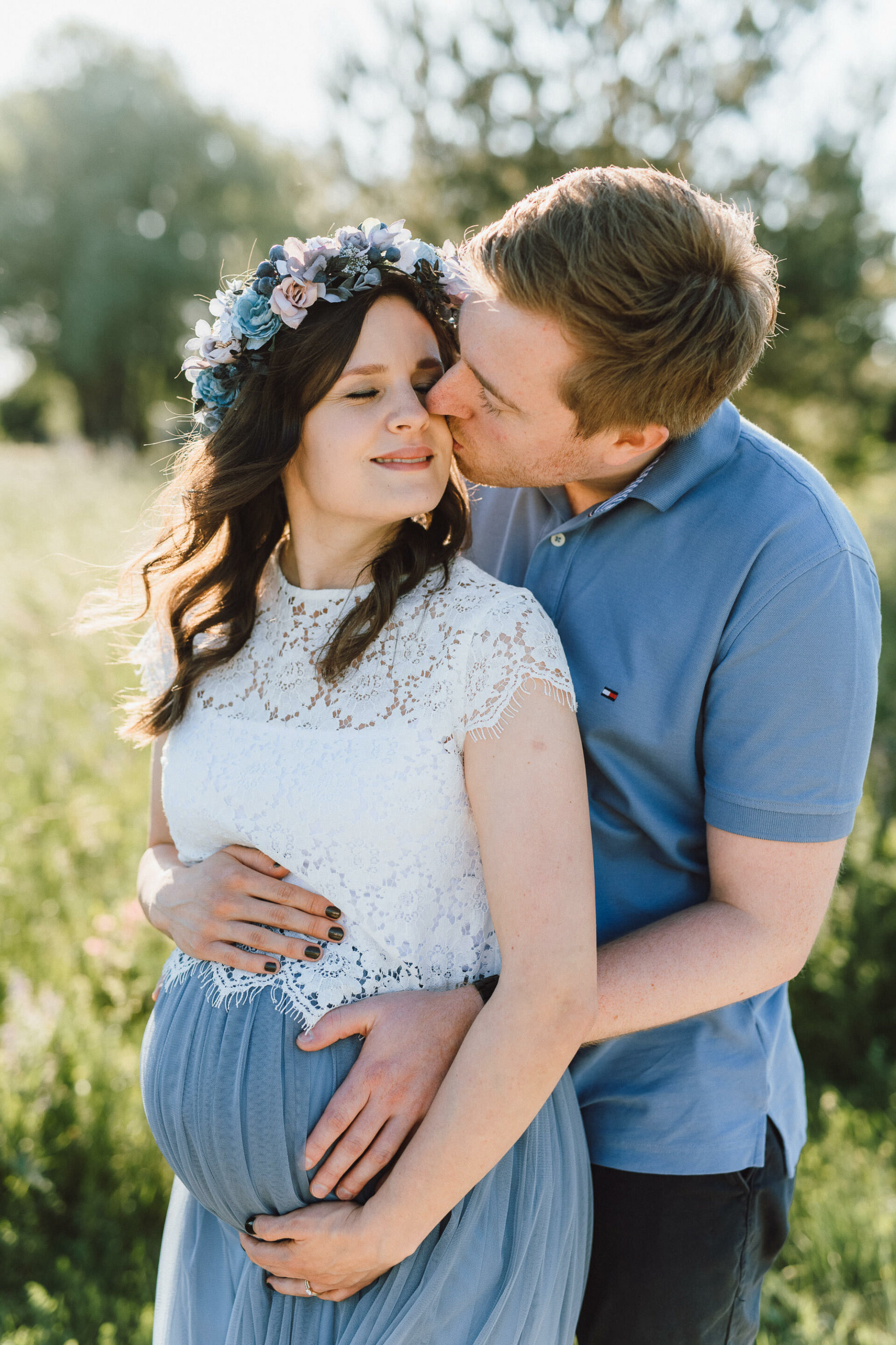 Paar in Blumenwiese mit Babybauch